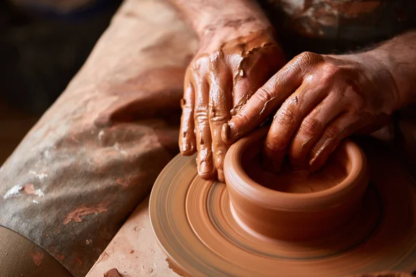 Close-up van de handen van een mannelijke potter in mallen schort kom uit klei, selectieve aandacht — Stockfoto