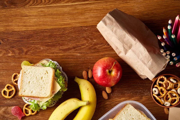 Concept van school lunchpauze met gezonde lunch box en school supplies op houten bureau, selectieve aandacht. — Stockfoto