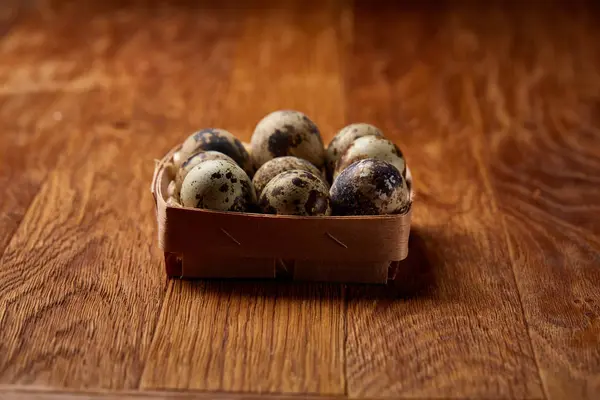 Huevos de codorniz en una caja sobre un fondo rústico de madera, vista superior, enfoque selectivo . — Foto de Stock
