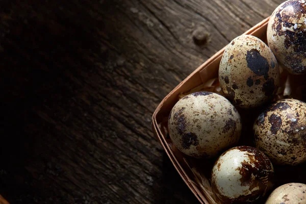 Huevos de codorniz en una caja sobre un fondo de madera vintage, vista superior, enfoque selectivo . — Foto de Stock