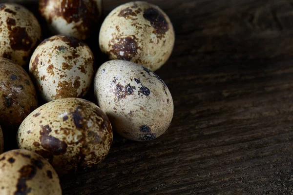 Huevos de codorniz moteados dispuestos sobre el fondo de viejas tablas de madera, con espacio de copia, enfoque selectivo . — Foto de Stock