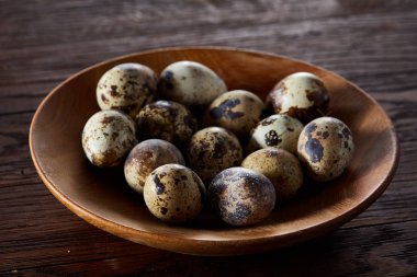 Taze bıldırcın yumurtası ahşap bir plaka üzerinde bir koyu ahşap arka plan, üstten görünüm, yakın çekim