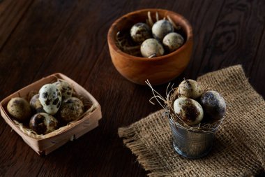 Bıldırcın yumurtası kova, kutu ve ıslak zeminde ahşap arka plan, seçici odak keten bir peçete ile rustik natürmort