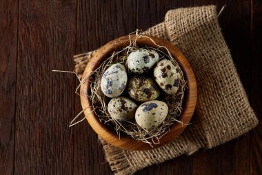 Bıldırcın yumurtası kova, kutu ve ıslak zeminde ahşap arka plan, seçici odak keten bir peçete ile rustik natürmort