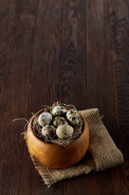 Bir koyu ahşap arka plan, üstten görünüm, yakın çekim bir ahşap kase taze bıldırcın yumurtası