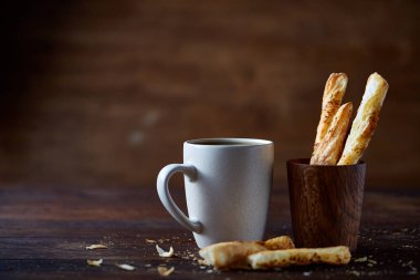 Kahve fincanı ve breadsticks bir eski ahşap arka plan, yakın çekim, seçici odak.