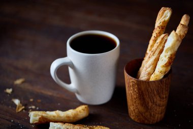 Kahve fincanı ve breadsticks bir eski ahşap arka plan, yakın çekim, seçici odak.