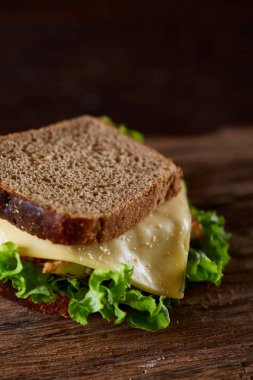 Lezzetli ve taze sandviç kesme tahtası üzerinde bir koyu ahşap arka plan üzerinde yakın çekim
