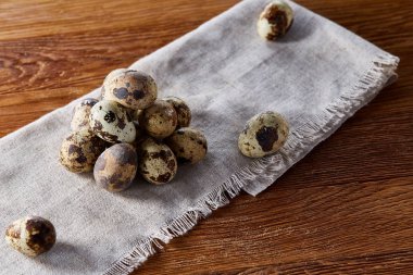 Piramit peçeteye düzenlenen bir ahşap masa, yakın çekim, seçici odak üzerinde bıldırcın yumurtası.