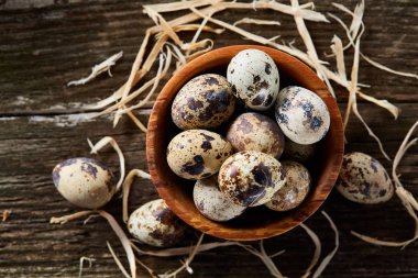 Ahşap kase bıldırcın yumurtası ahşap tahta üzerinde dolu beyaz arka plan, yakın çekim, seçici odak üzerinde.