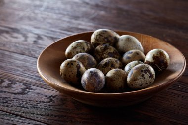 Taze bıldırcın yumurtası ahşap bir plaka üzerinde bir koyu ahşap arka plan, üstten görünüm, yakın çekim