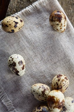 Piramit peçeteye Şimşir dalları ile düzenlenmiş bir ahşap masa, yakın çekim, seçici odak üzerinde bıldırcın yumurtası.