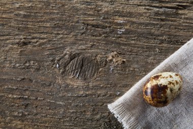 Piramit peçeteye Şimşir dalları ile düzenlenmiş bir ahşap masa, yakın çekim, seçici odak üzerinde bıldırcın yumurtası.