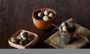 Bıldırcın yumurtası kova, kutu ve ıslak zeminde ahşap arka plan, seçici odak keten bir peçete ile rustik natürmort