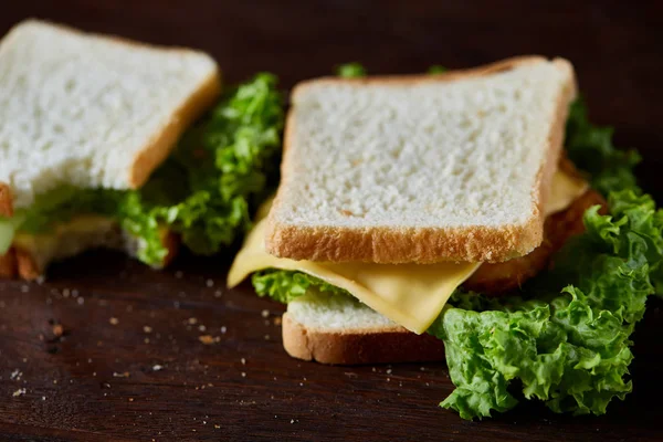 Lezzetli ve taze sandviç kesme tahtası üzerinde bir koyu ahşap arka plan üzerinde yakın çekim