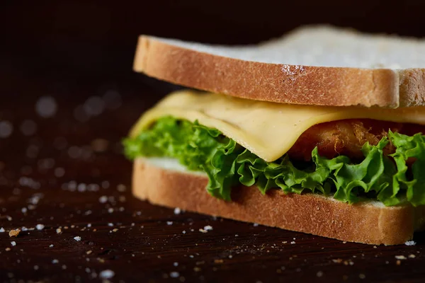 Lezzetli ve taze sandviç kesme tahtası üzerinde bir koyu ahşap arka plan üzerinde yakın çekim