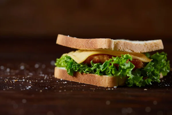 Sándwiches sabrosos y frescos en la tabla de cortar sobre un fondo de madera oscura, primer plano —  Fotos de Stock