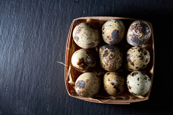 Bıldırcın yumurtası içinde bir koyu siyah arka plan, üstten görünüm, seçici odak, arkadan bir sille.
