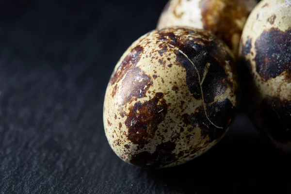 Bazı Bıldırcın yumurta bir koyu arka plan, üstten görünüm, yakın çekim, seçici odak grup, uzay kopyalayın, aydınlatma.
