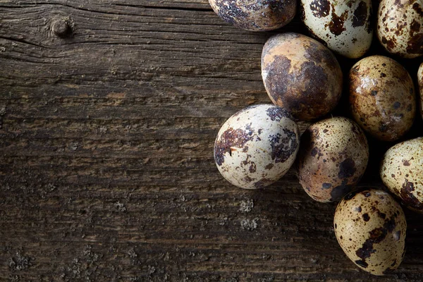 Huevos de codorniz moteados dispuestos sobre el fondo de viejas tablas de madera, con espacio de copia, enfoque selectivo . — Foto de Stock