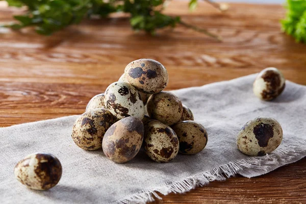 Piramit peçeteye düzenlenen bir ahşap masa, yakın çekim, seçici odak üzerinde bıldırcın yumurtası.