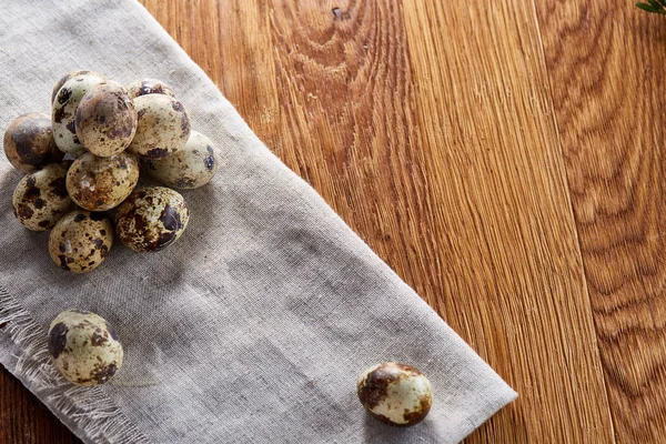 Piramit peçeteye düzenlenen bir ahşap masa, yakın çekim, seçici odak üzerinde bıldırcın yumurtası.