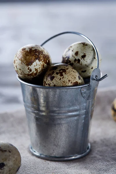 Küçük dekoratif kova peçete bıldırcın yumurtalarının dolu beyaz dokulu arka plan, yakın çekim, seçici odak üzerinde.