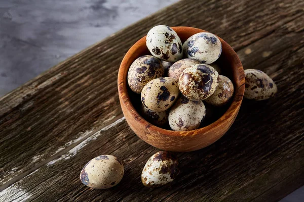 Ahşap kase bıldırcın yumurtası ahşap tahta üzerinde dolu beyaz arka plan, yakın çekim, seçici odak üzerinde.