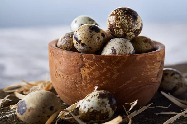 Ahşap kase bıldırcın yumurtası ahşap tahta üzerinde dolu beyaz arka plan, yakın çekim, seçici odak üzerinde.