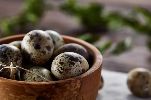 Kom met eieren kwartel, eieren op een homespun servet, buxus op houten achtergrond, close-up, selectieve aandacht — Stockfoto