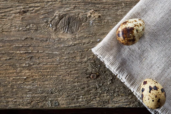 Huevos de codorniz dispuestos en pirámide en una servilleta con ramas de boj sobre una mesa de madera, primer plano, enfoque selectivo . — Foto de Stock