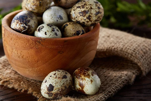 Cuenco con huevos de codorniz, huevos en una servilleta hecha en casa, boj sobre fondo de madera, primer plano, enfoque selectivo — Foto de Stock