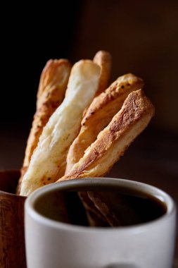 Kahve fincanı, breadsticks ve kruvasan bir eski ahşap arka plan, yakın çekim, seçici odak.
