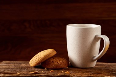 Ahşap ahşap arka plan, üstten görünüm, seçici odak parçası üzerinde çay ve tatlı kurabiye beyaz porselen kupa