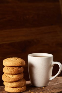 Ahşap ahşap arka plan, üstten görünüm, seçici odak parçası üzerinde çay ve tatlı kurabiye beyaz porselen kupa