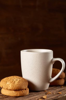 Ahşap ahşap arka plan, üstten görünüm, seçici odak parçası üzerinde çay ve tatlı kurabiye beyaz porselen kupa