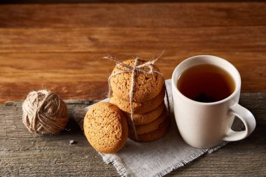 Geleneksel Noel çay bir fincan sıcak çay, kurabiye ve süslemeleri üzerinde ahşap bir masa, seçici odak konseptiyle