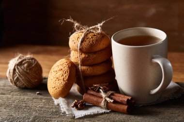 Geleneksel Noel çay bir fincan sıcak çay, kurabiye ve süslemeleri üzerinde ahşap bir masa, seçici odak konseptiyle