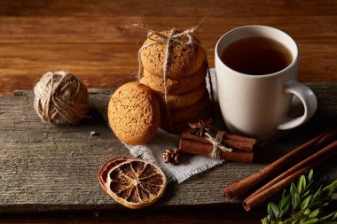 Geleneksel Noel çay bir fincan sıcak çay, kurabiye ve süslemeleri üzerinde ahşap bir masa, seçici odak konseptiyle