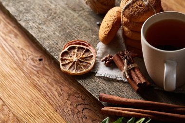 Geleneksel Noel çay bir fincan sıcak çay, kurabiye ve süslemeleri üzerinde ahşap bir masa, seçici odak konseptiyle