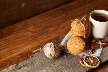 Geleneksel Noel çay bir fincan sıcak çay, kurabiye ve süslemeleri üzerinde ahşap bir masa, seçici odak konseptiyle