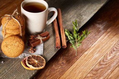 Geleneksel Noel çay bir fincan sıcak çay, kurabiye ve süslemeleri üzerinde ahşap bir masa, seçici odak konseptiyle