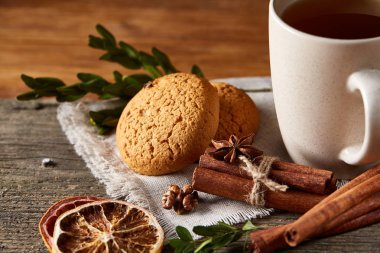 Geleneksel Noel çay bir fincan sıcak çay, kurabiye ve süslemeleri üzerinde ahşap bir masa, seçici odak konseptiyle