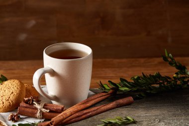 Geleneksel Noel çay bir fincan sıcak çay, kurabiye ve süslemeleri üzerinde ahşap bir masa, seçici odak konseptiyle