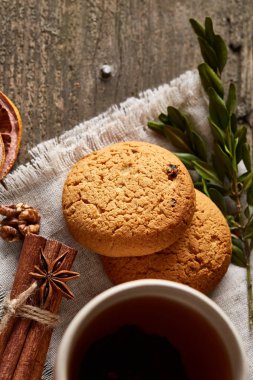 Tanımlama bilgileri, tarçın ve hafif ahşap arka plan üzerinde kurutulmuş portakal yığını ile Noel kompozisyon yakın çekim.