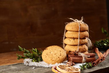 Tanımlama bilgileri, tarçın ve hafif ahşap arka plan üzerinde kurutulmuş portakal yığını ile Noel kompozisyon yakın çekim.