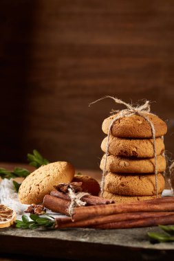 Tanımlama bilgileri, tarçın ve hafif ahşap arka plan üzerinde kurutulmuş portakal yığını ile Noel kompozisyon yakın çekim.