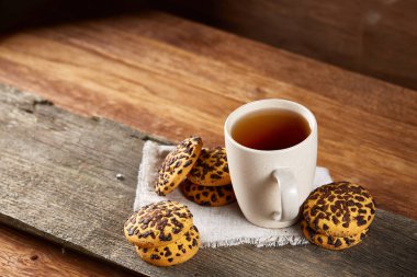 Fincan çay ve Çikolata parçalı kurabiye ülke tarzı, seçici odak beyaz saf peçete üzerinde.