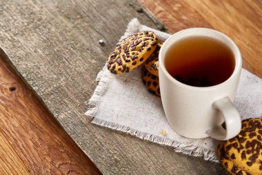 Fincan çay ve Çikolata parçalı kurabiye ülke tarzı, seçici odak beyaz saf peçete üzerinde.