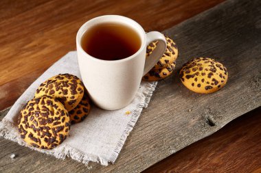 Fincan çay ve Çikolata parçalı kurabiye ülke tarzı, seçici odak beyaz saf peçete üzerinde.